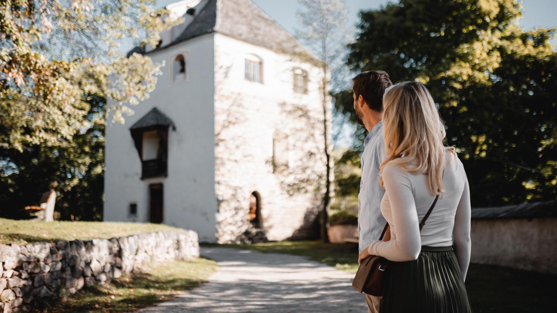 Ein Mann und eine Frau blicken auf die St. Valentin Kirche
