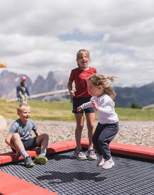 Drei Kinder hüpfen Trampolin