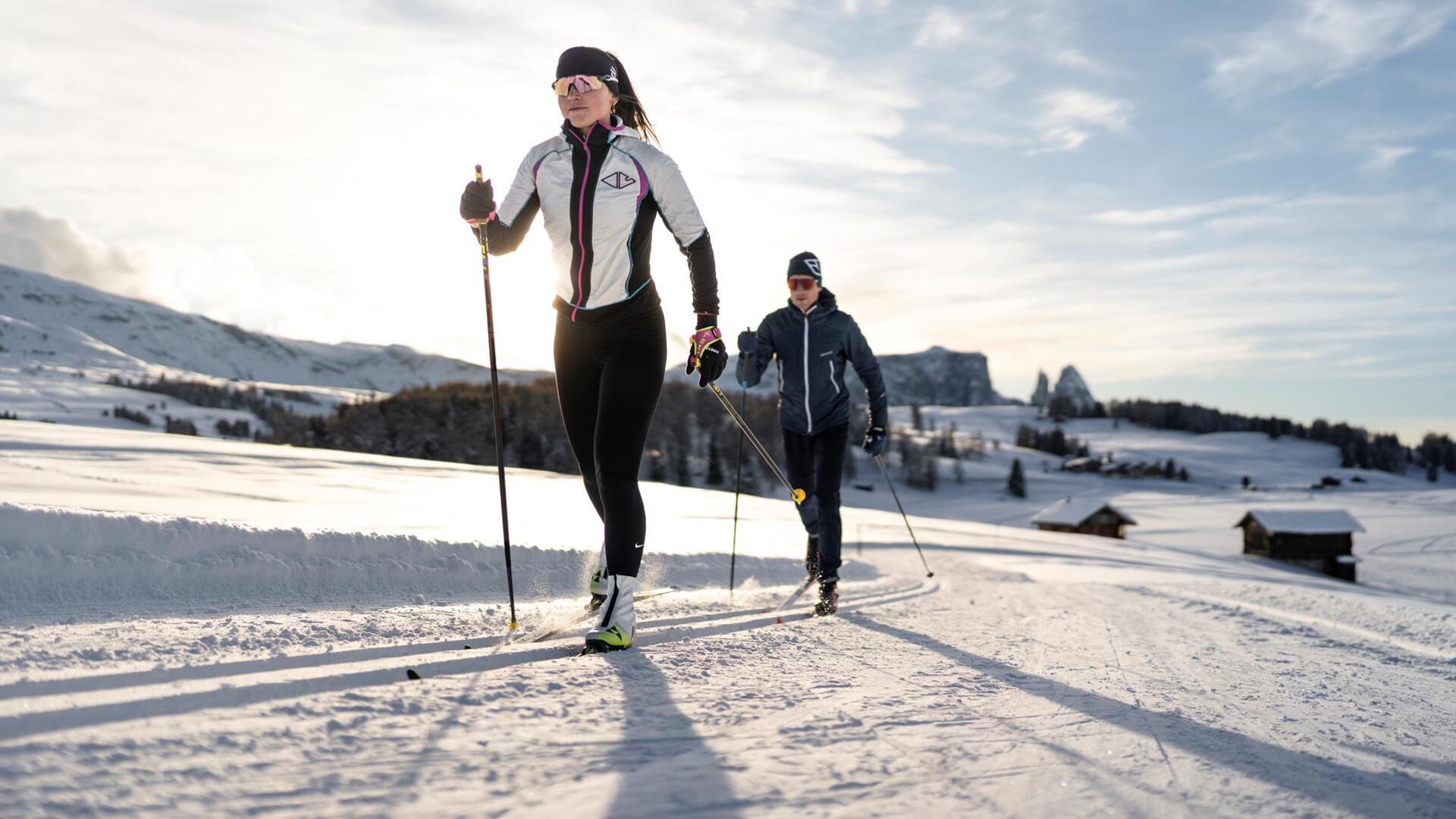 Two people are cross-country skiing on the Seiser Alm