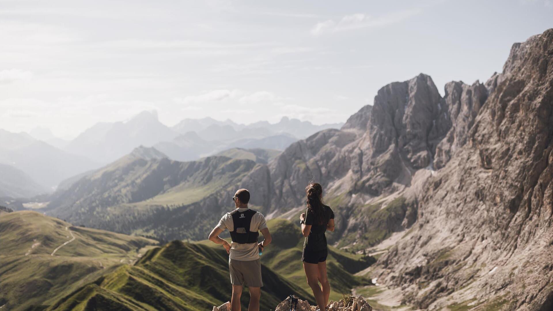 A man and a woman are trail running on the Seiser Alm