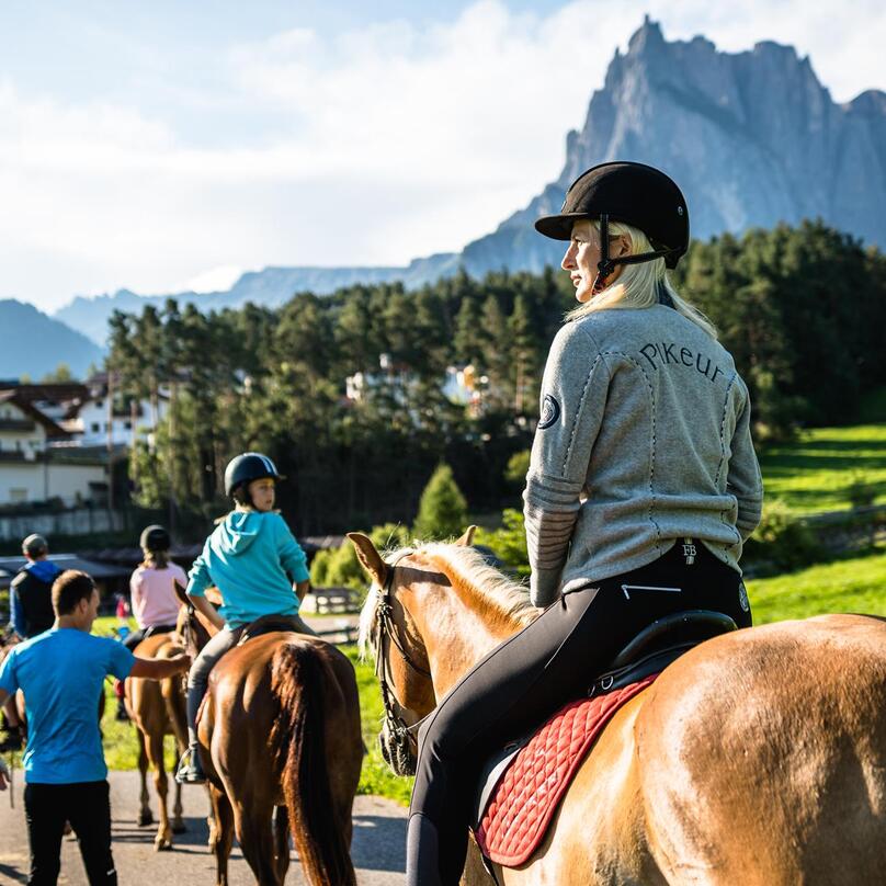Un gruppo di persone cavalca dei cavalli