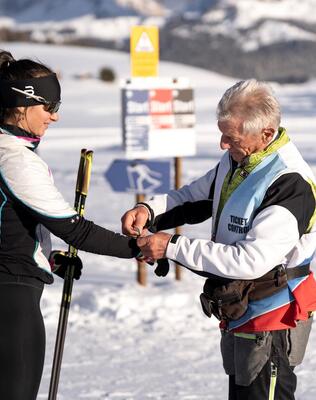 Zwei Personen bezahlen den Eintritt an der Langlaufloipe