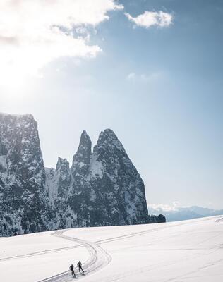 Two people are cross-country skiing on the Seiser Alm