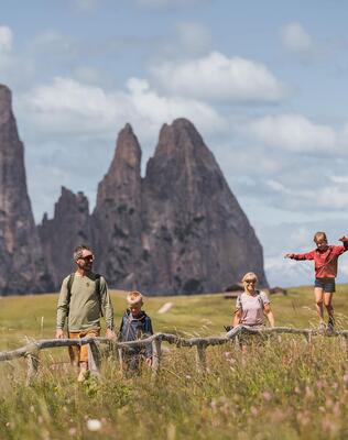 Eine Familie mit zwei Kindern beim Wandern auf der Seiser Alm