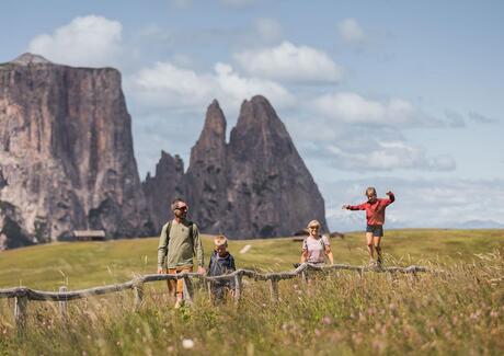 Eine Familie mit zwei Kindern beim Wandern auf der Seiser Alm
