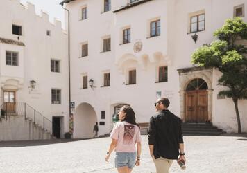 A man and a woman stroll through Kastelruth