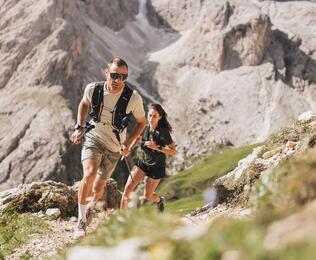 Ein Mann und eine Frau beim Trailrun auf der Seiser Alm