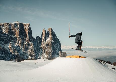 Un bambino nello snowpark Alpe di Siusi, con lo Sciliar sullo sfondo