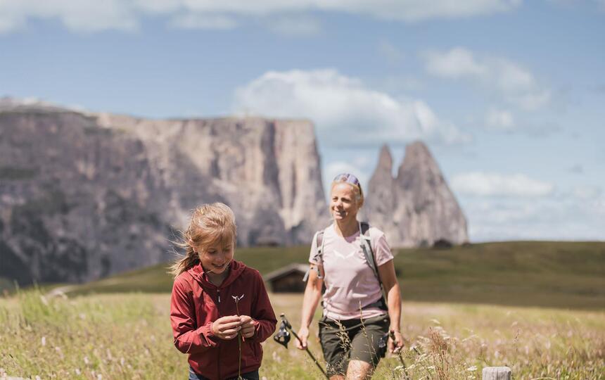 A woman and a man are hiking on Seiser Alm