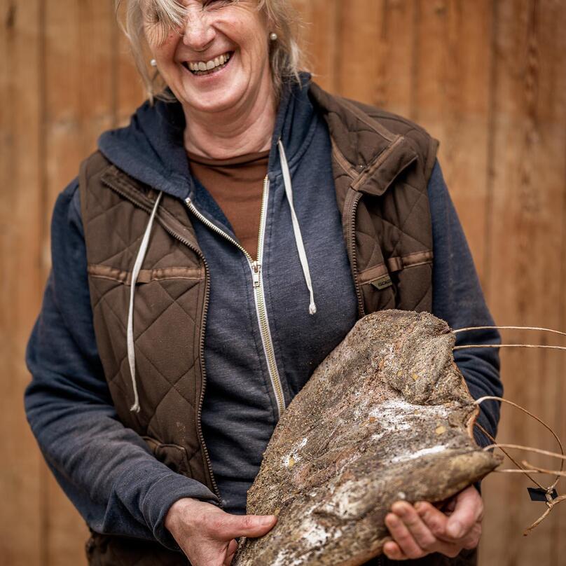 Eine Frau hält ein Stück Speck dabei