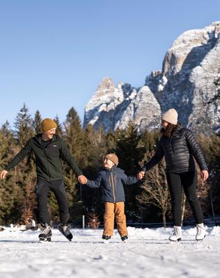 Eine Familie mit einem Kind läuft Schlittschuh