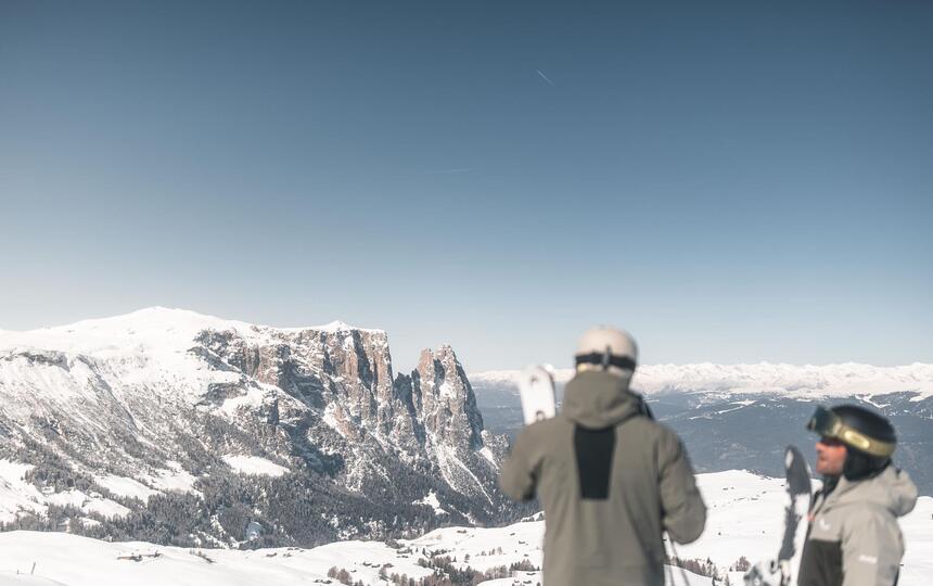 Due uomini in attrezzatura da sci guardano lo Sciliar