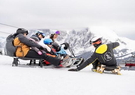 Eine Gruppe von Personen beim Rodeln im Winter