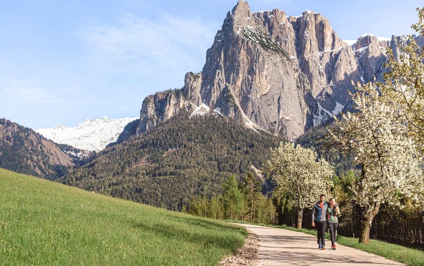 Un uomo e una donna passeggiano ai piedi dello Sciliar.