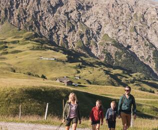 ine Familie mit zwei Kindern unterwegs auf der Seiser Alm.