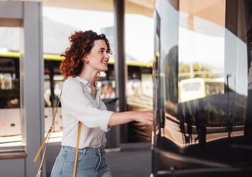 A woman is getting on a bus
