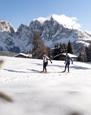 Two people are cross-country skiing on the Seiser Alm
