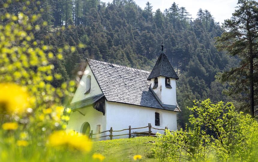 Kapelle umgeben von blühenden Wiesen