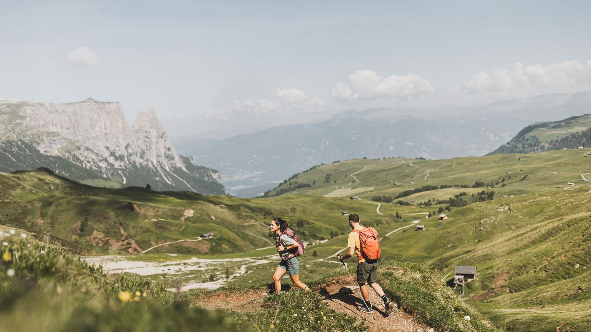 Eine Frau und ein Mann wandern auf der Seiser Alm