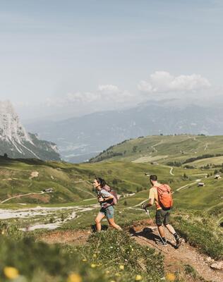 Eine Frau und ein Mann wandern auf der Seiser Alm