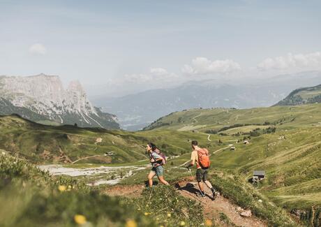 Eine Frau und ein Mann wandern auf der Seiser Alm