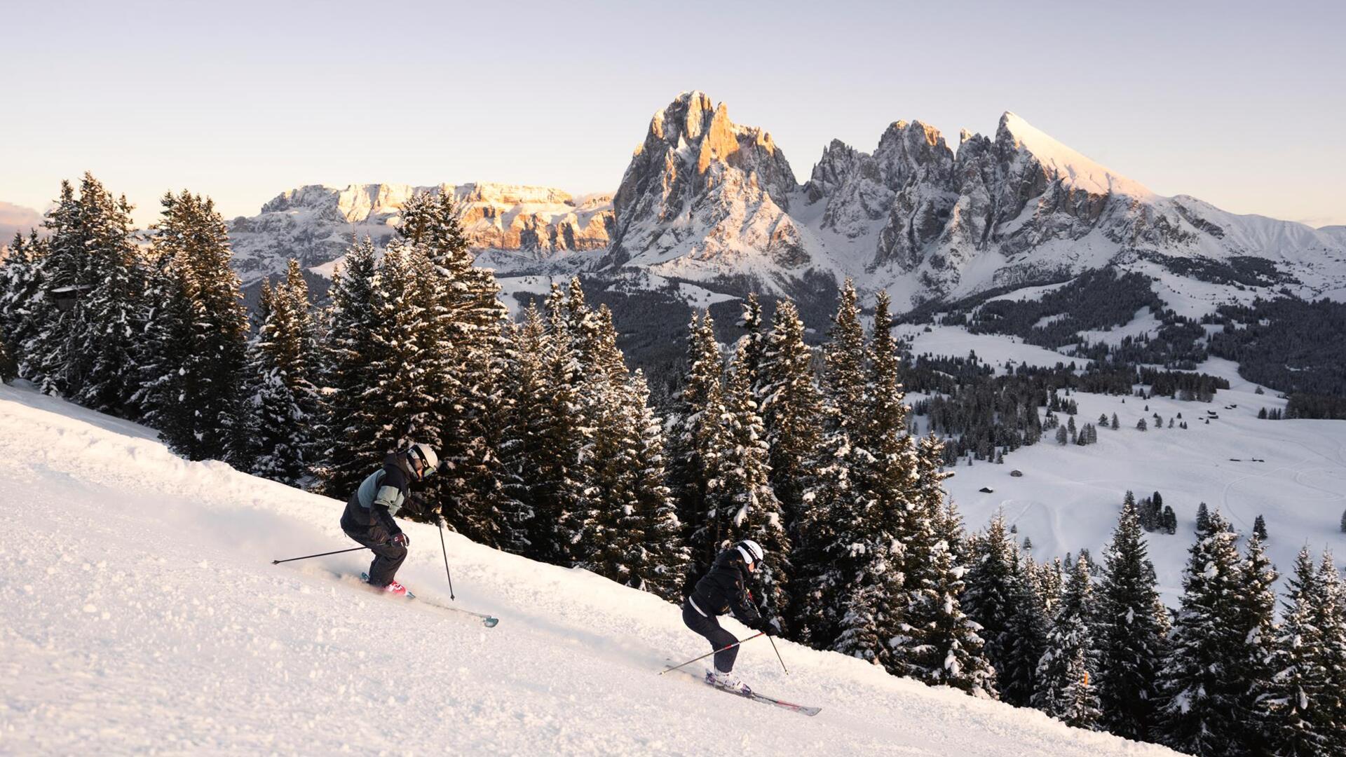Un uomo e una donna scendono lungo una pista da sci