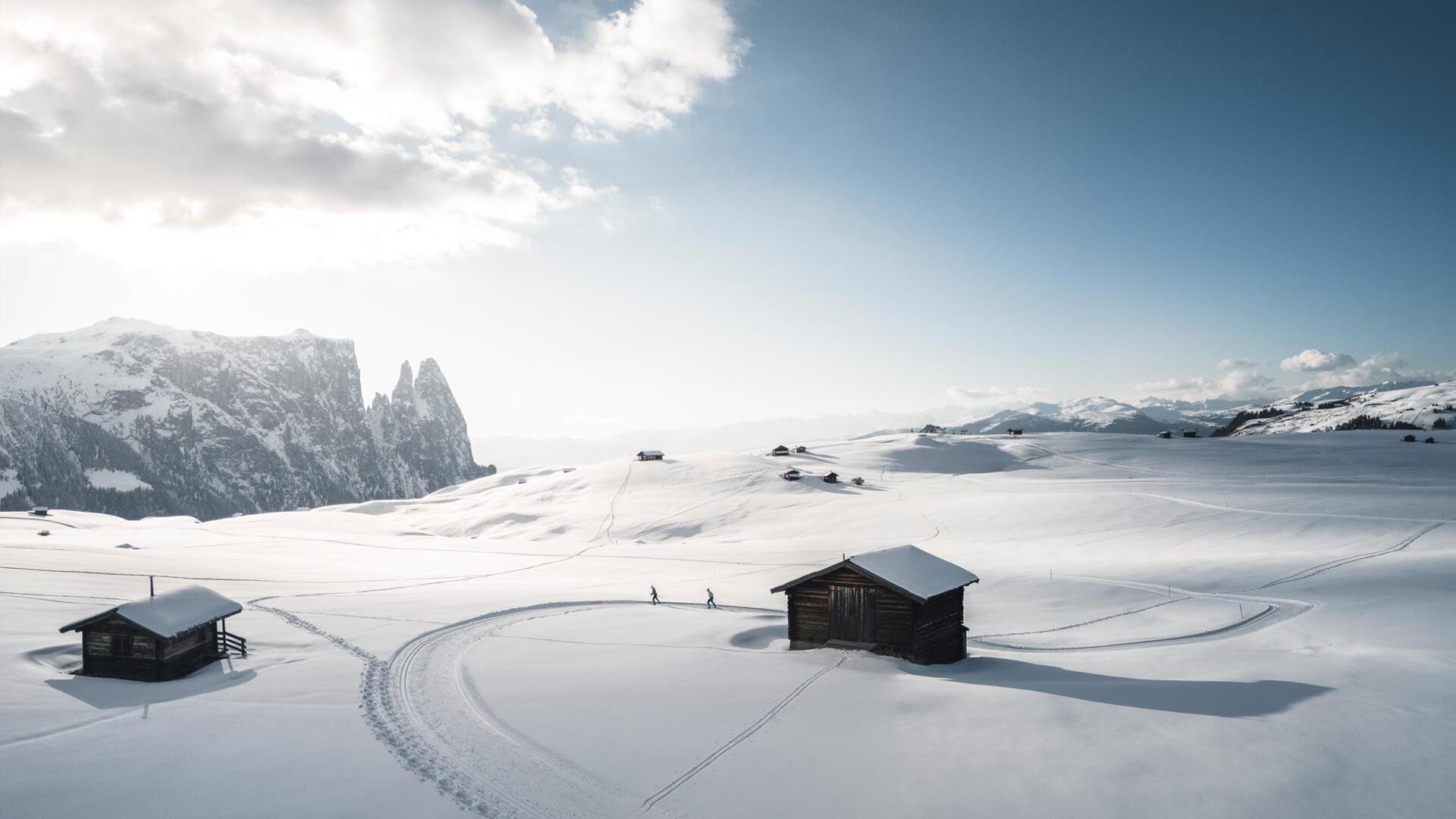 Two people are cross-country skiing on the Seiser Alm