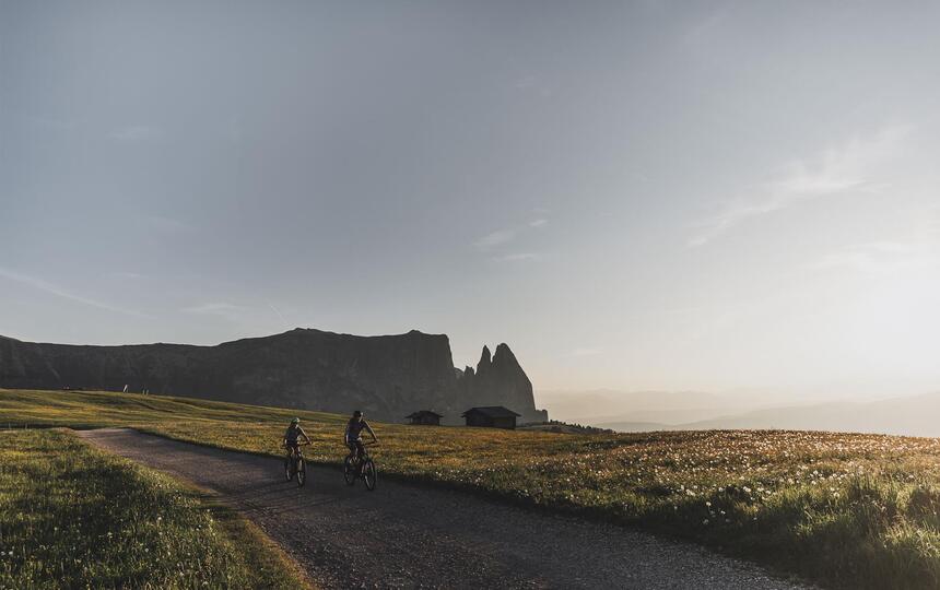 Zwei Mountainbiker sind auf der Seiser Alm unterwegs