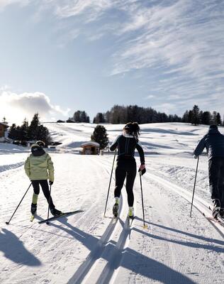 Eine Familie mit zwei Kindern beim Langlaufen auf der Seiser Alm