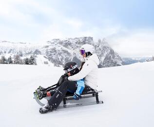 Eine Frau und ein Kind beim rodeln