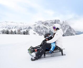 Eine Frau und ein Kind beim rodeln