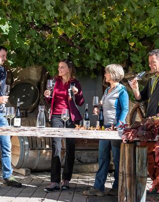 Eine Gruppe von Personen trinkt ein Glas Rotwein