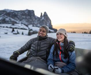 Ein Mann und eine Frau sitzen in einer Pferdekutsche