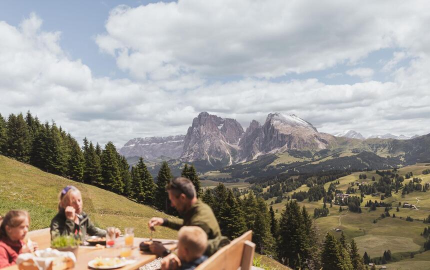 Eine Familie sitzt an einem Holztisch und isst gemeinsam