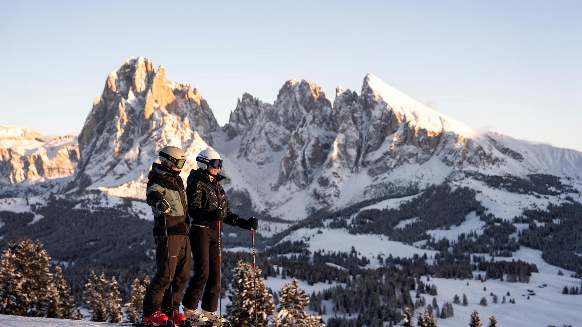 Ein Mann und eine Frau fahren eine Skipiste hinunter