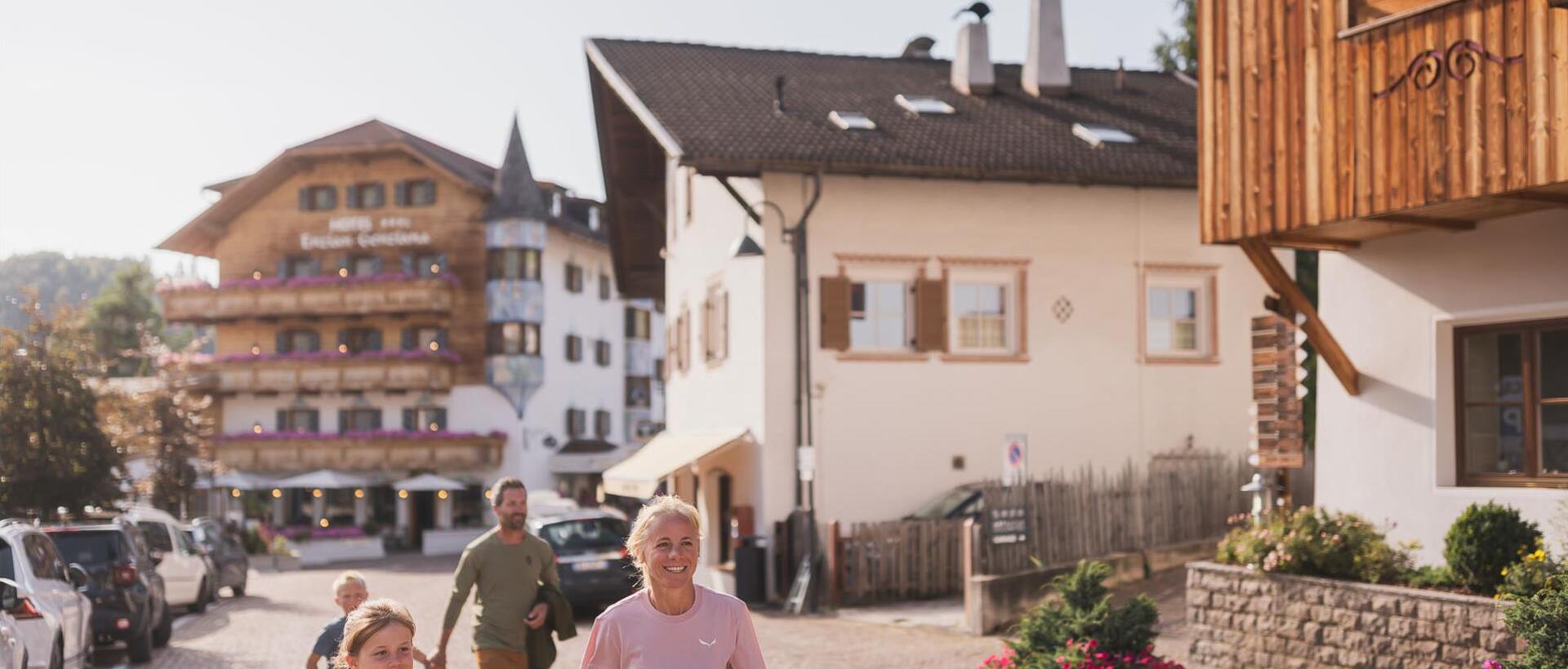 A family with two children is walking through Seis am Schlern