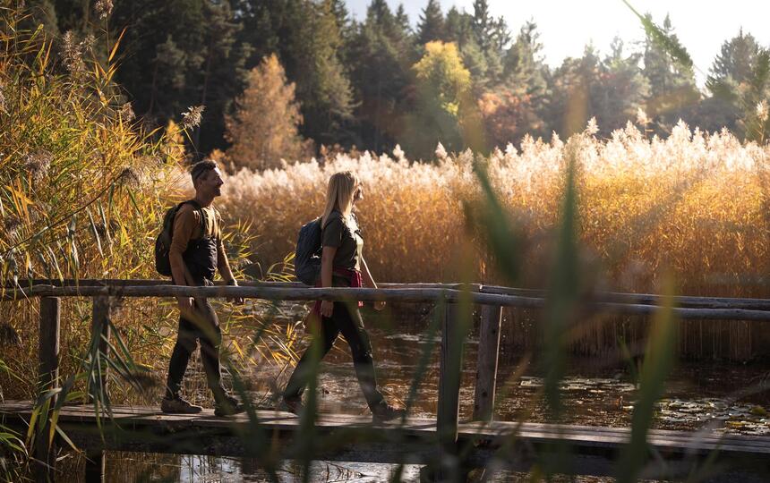 A man and a woman walk across a bridge