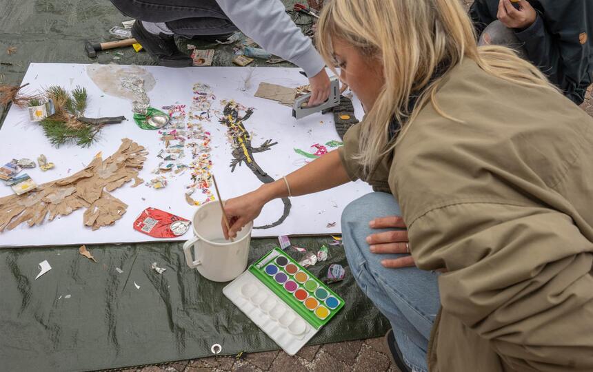 Un gruppo di persone realizza un quadro con materiali naturali