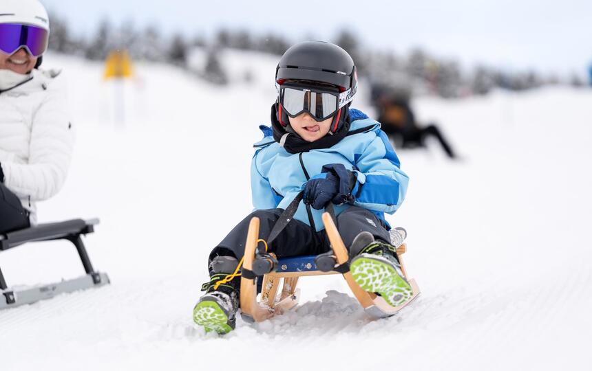 Eine Frau mit einem Kind beim Rodeln